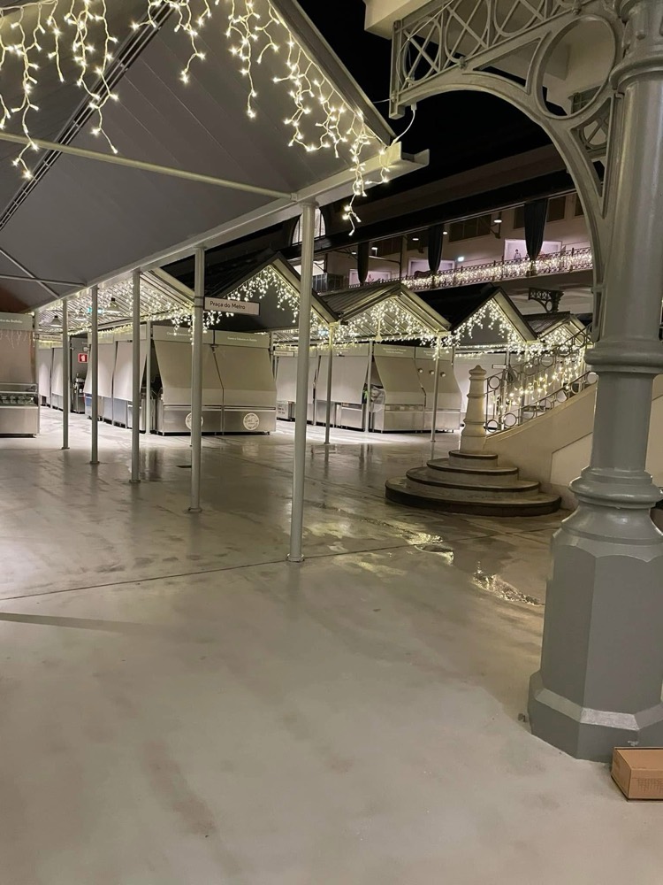 Bancas de mercado com telhados de duas águas decorados com franjas de luz